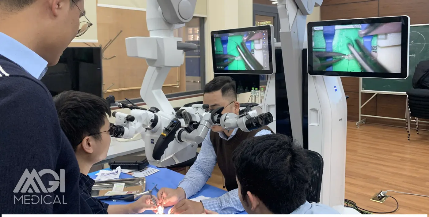 Học viên tập dưới kính vi phẫu, thao tác được chiếu trực tiếp lên màn hình — Khoá đào tạo vi phẫu cơ bản trong phẫu thuật thần kinh, Bộ môn Ngoại, Trường Đại học Y Hà Nội. Ảnh: MGI Medical.